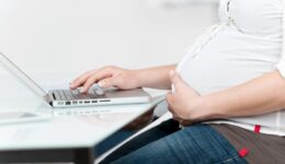 gravidanza2-1024×683 21246714 - midsection of pregnant woman with hand on belly using laptop at table in house