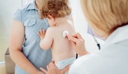Friendly doctor pediatrician with patient child at clinic. Diagnostic, healthcare, medical service