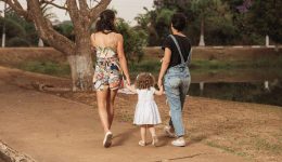 couple of women walking hand in hand with daughter