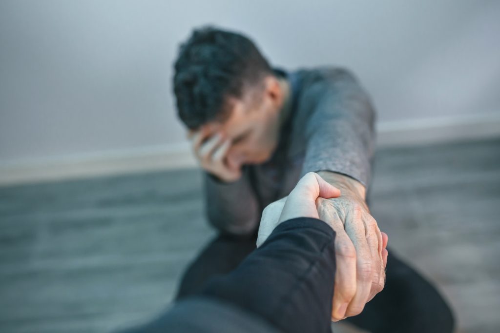 Unrecognizable man with problems receiving help from woman holding her hand Unrecognizable man with problems receiving help from woman holding her hand. Helping hand concept