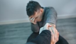 Unrecognizable man with problems receiving help from woman holding her hand. Helping hand concept