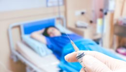 Medical syringe in the doctor's hands on the patient's in room hospital blur background