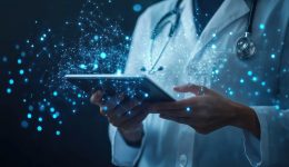 Healthcare professional wearing white coat and stethoscope using digital tablet with holographic medical data and futuristic technology in a clinical environment.